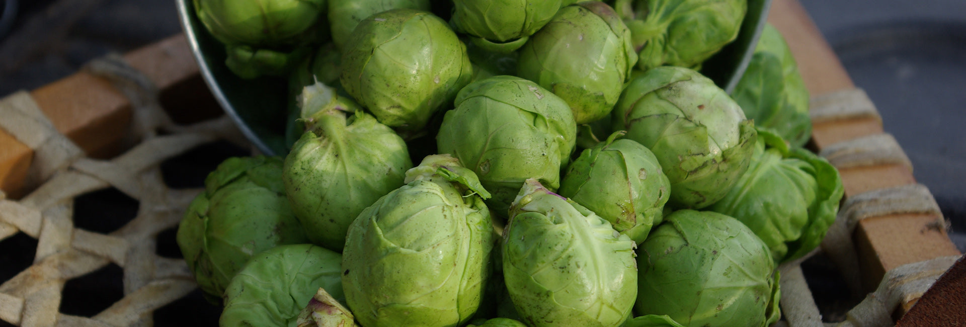 Brussels sprouts in a metal bowl on a wooden surface