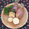 Top view of Marian rutabaga roots showcasing yellow flesh and purple tops on a round plate