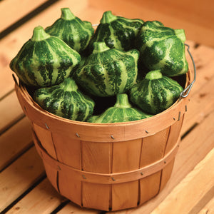 Top view of Green Lightning summer squash showing scalloped, green-striped fruits in a wooden bushel basket on a wooden table