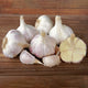 Close-up front view of Ivan garlic bulbs showcasing large cloves and porcelain skin on a wooden surface