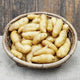 Top-down view of Austrian Crescent fingerling potatoes in a bowl showing pale yellow skin and crescent shape on a light background