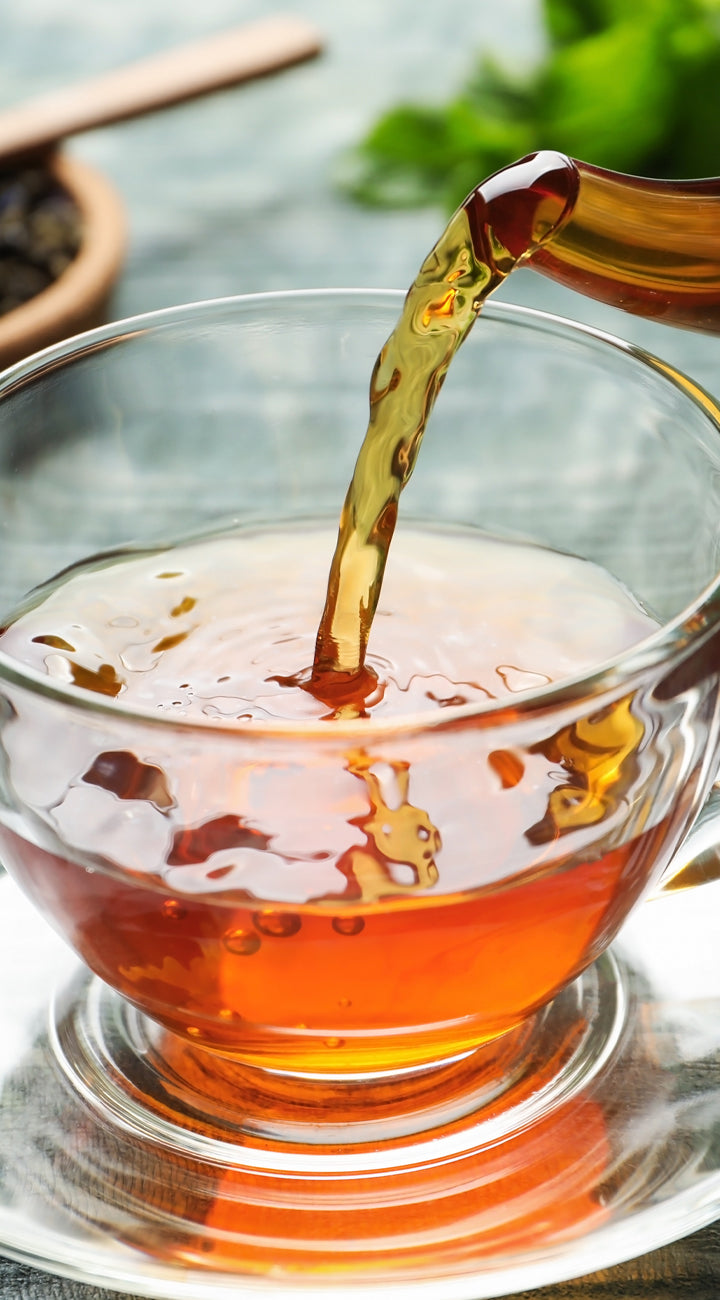 Yerba buena tea being poured into a glass cup, close-up