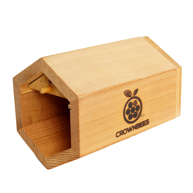 Three-quarter view of Cabana bee house showing cedar construction, open hexagonal front and CrownBees logo on white background