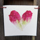 Front view of produce flag showcasing a watercolor lettuce heart on white UV-protected canvas, hand-strung with hemp cord on a wooden fence