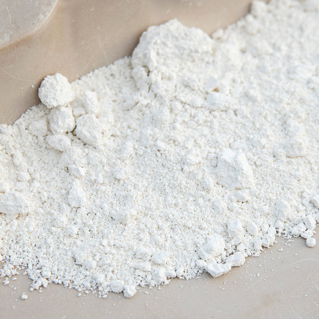 Close-up of Surround WP wettable kaolin clay powder showing fine white powder texture on a neutral background