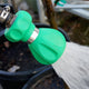 Green garden hose nozzle spraying water with a blurred background