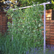 Angled view of Freyr trellis support showing metal frame with climbing plants against a wooden fence
