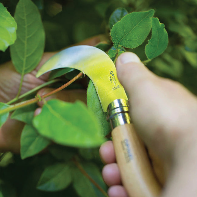 Side view of No. 10 Opinel billhook folding knife showing curved stainless-steel blade and birch handle