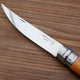 Close-up of Effilé No. 10 harvesting knife showing stainless-steel blade and Opinel logo on a wooden surface
