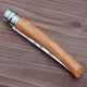 Folded view of Effilé No 10 harvesting knife showcasing light wood handle and folded stainless-steel blade on a wooden background