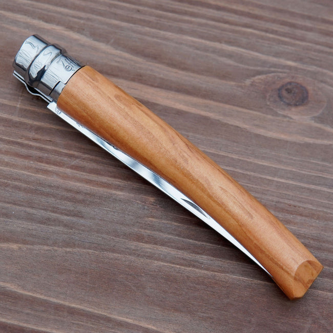 Folded view of Effilé No 10 harvesting knife showcasing light wood handle and folded stainless-steel blade on a wooden background