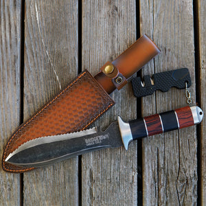 Angled view of The Hero Hori tool with 7.5-inch double-sided blade, cocobolo handle, and leather sheath on wood