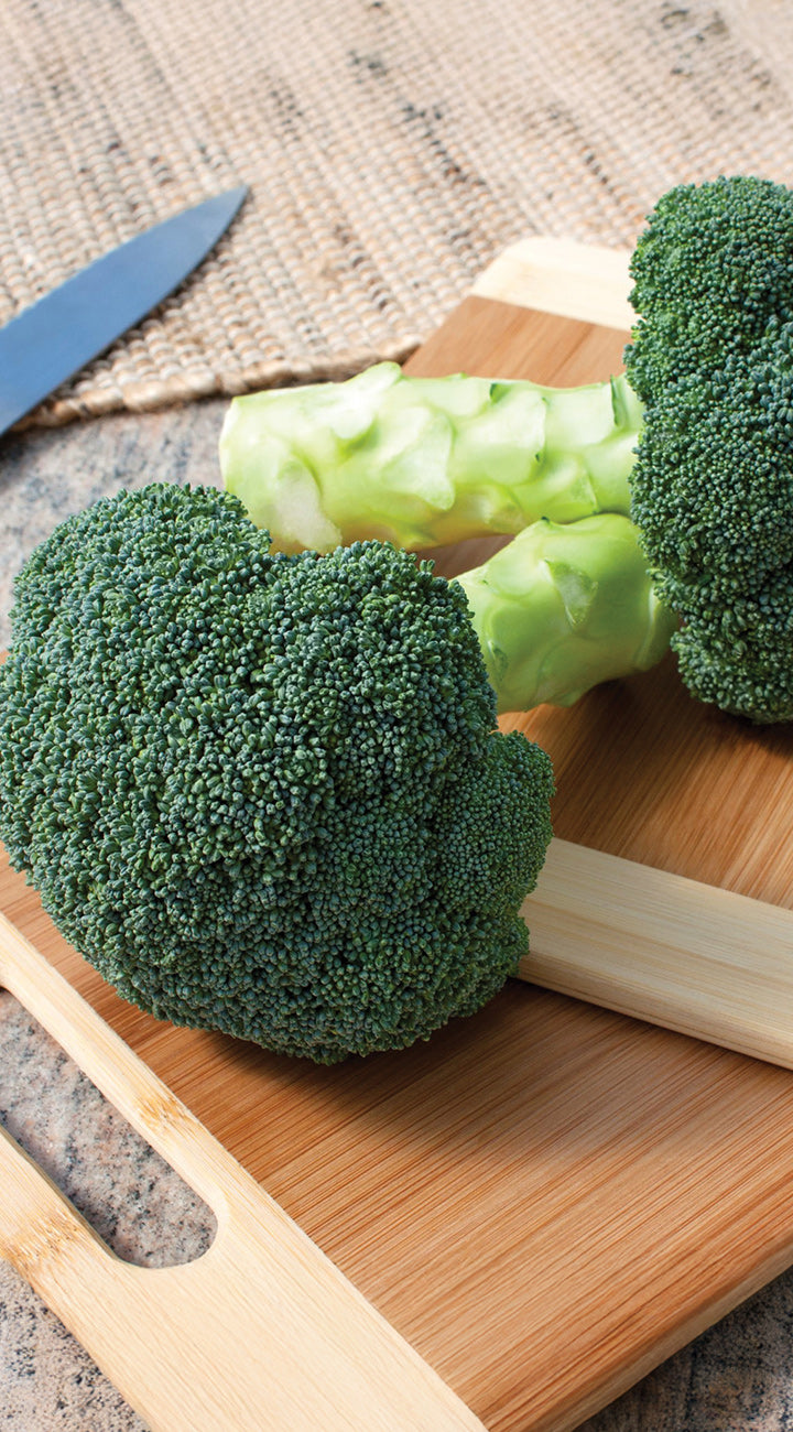 Broccoli on a wooden cutting board with a knife