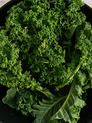 Close-up of curly green kale leaves on a black plate