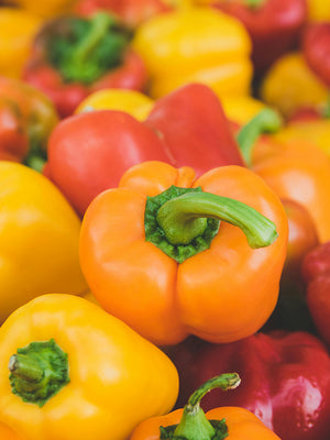 Close-up of colorful bell peppers including orange, yellow, and red.