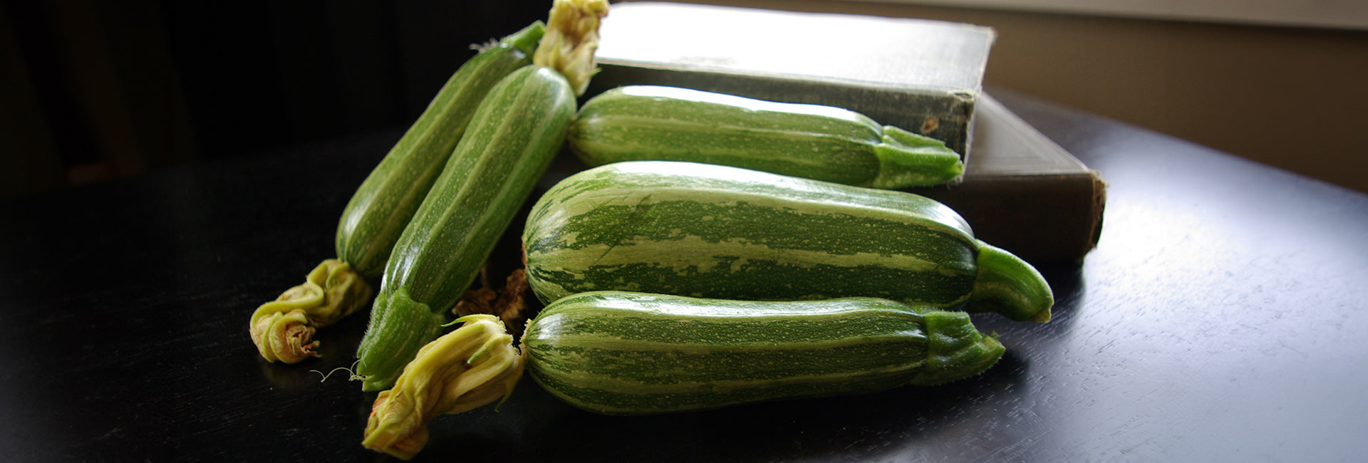 Summer squash on a dark surface with a white cloth