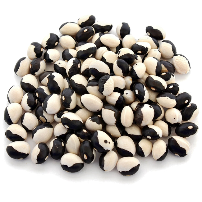 Close-up of Yin Yang bean seeds showcasing black-and-white yin-yang markings on a white background