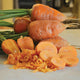 Close-up of Oxheart carrots showing whole heart-shaped roots, sliced rounds and shredded carrot on a light countertop