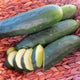 Close-up of Marketmore 97 cucumbers showcasing a partial slice that reveals pale green flesh and seeds and dark green smooth skin on a woven basket background