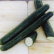 Close up of Pepinex English cucumbers showing long slender shape and smooth dark green skin, one sliced on a light background