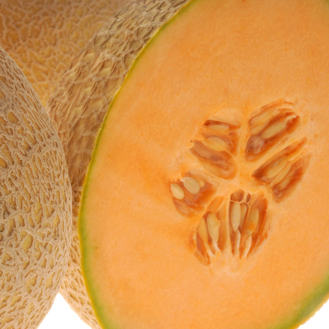 Close-up of Home Run cantaloupe melon cut in half showing bright orange flesh, central seeds, and coarse netted rind on white background