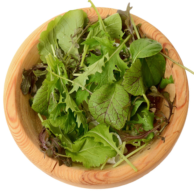 Close-up of Organic Mustard Mix salad greens showcasing mixed leaf shapes and green and purple hues on white background