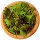 Overhead view of Market Mustard Mix in a wooden bowl showing red and green frilly mustard greens