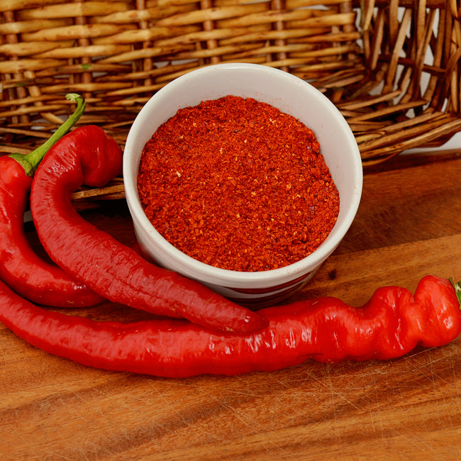 Front view of Arapaho cayenne pepper plant showing 8-9 inch wrinkled red pods and green foliage