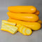 Front view of Yellowfin summer squash showing whole and sliced golden-yellow cylinders with pale buttery flesh on white background