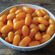 Close-up of Gold Spark grape tomatoes showing elongated golden-yellow fruits in a bowl
