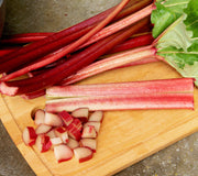 Front view of Crimson Red rhubarb showing deep red tender stalks and diced pieces on a wooden cutting board
