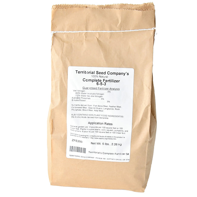 Front view of Territorial's Complete Fertilizer (dry) in a brown kraft paper bag showing the white product label on a white background