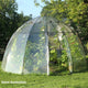 Front view of Sunbubble dome greenhouse showing clear PVC cover, zippered door, and curved fiberglass ribs on lawn