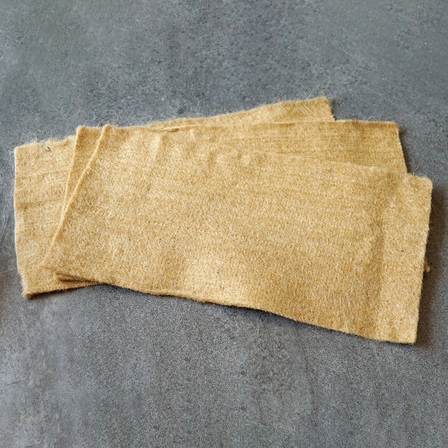 Top view of three hemp microgreens replacement grow mats showing fibrous texture and rectangular shape on a gray surface