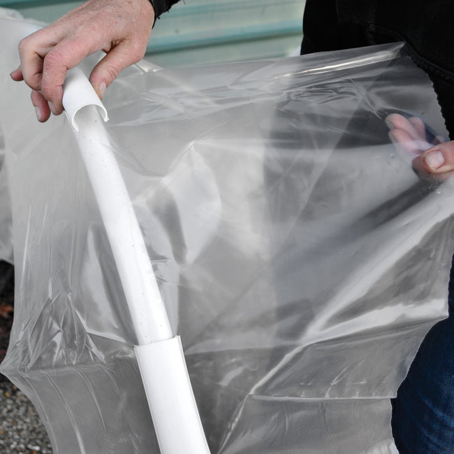 Close-up of medium Garden Clip fastening clear greenhouse plastic to 1/2-inch poly pipe