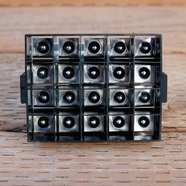 Angled view of Micro 20 soil blocker, black plastic, showing 20 square cavities for 3/4 inch soil blocks on white background