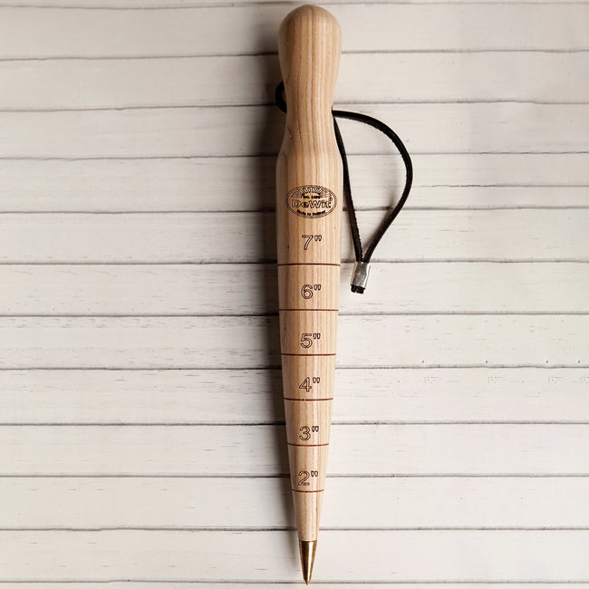 Angled view of DeWit 12-inch ash dibber showcasing brass tip, engraved inch markings, and leather hanging loop on white background