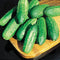 Three-quarter view of Regal pickling cucumbers showcasing small, bumpy, dark green fruits with white spines in a wooden bowl